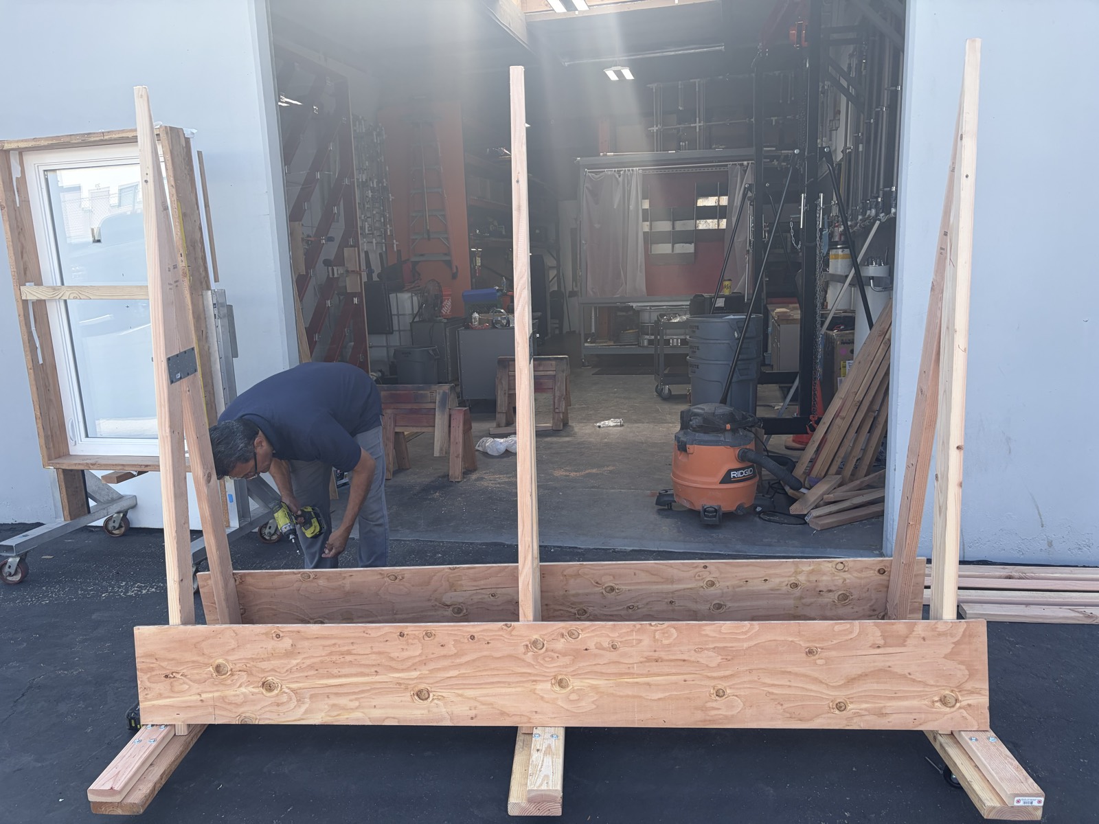 Jimmy Cruz assembling a custom wooden specimen stand outside the test bay, with a window unit staged on a cart